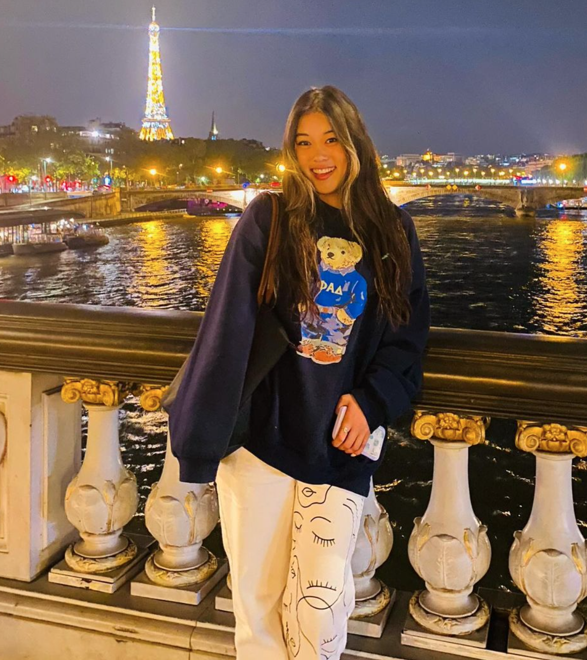 Katie Chen poses for a photo in front of the Seine River and Eiffel Tower.