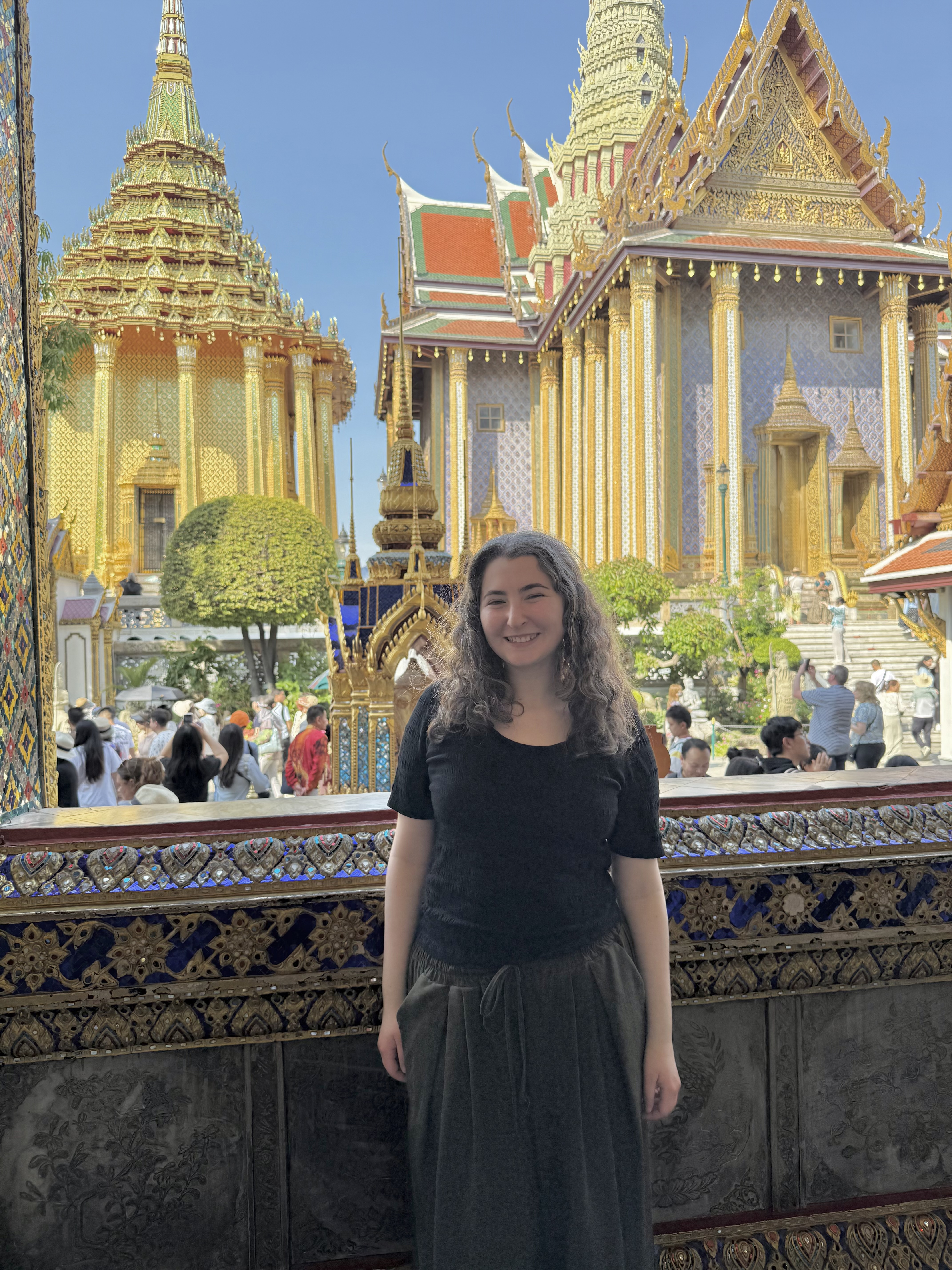 Ella Rimland smiles for a photo in front of a temple in Thailand.