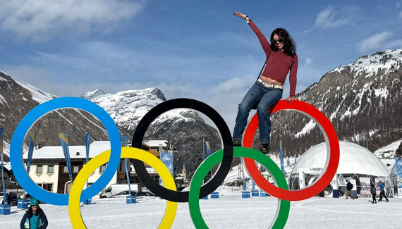 Finn Lutton ’27 poses with a statue of the Olympic rings.