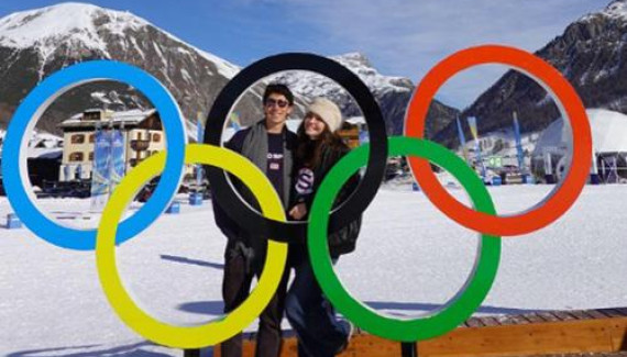Finn Lutton ’27 poses with a statue of the Olympic rings.