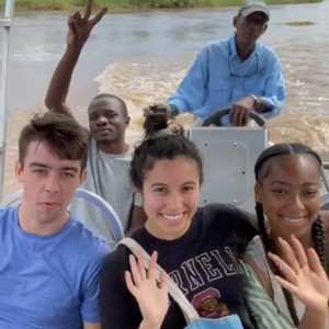 Cornell students ride on a boat in Zambia. 