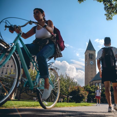 Students commuting across Cornell campus in front of McGraw tower