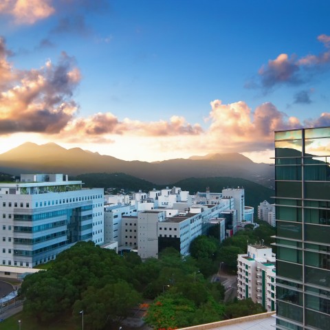 Skyline view of HKUST campus with glass building in the foreground